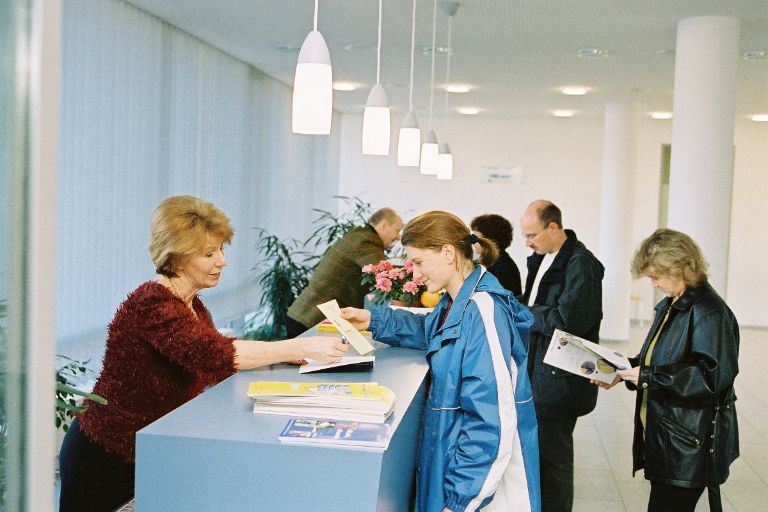 Personen, die an der Infothek in einem Sozialbürgerhaus Informationen bekommen.