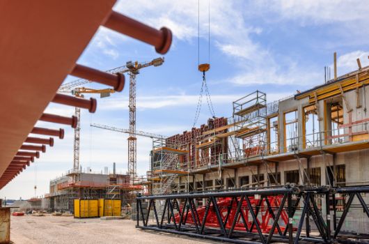 Ausleger des Raupenkran vor der Rückseite der Grundschule