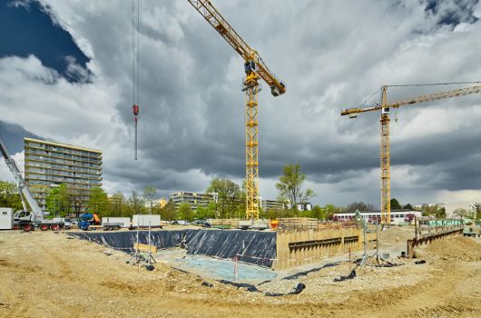 Baugrube Haus fuer Kinder mit Blick Bestandsturnhalle