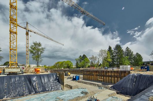 Baugrube Haus fuer Kinder mit Blick auf Grundschule
