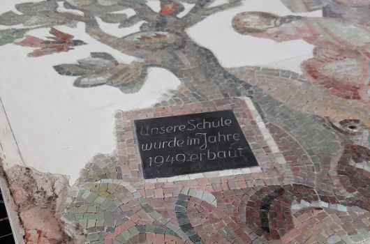 Ein Wandmosaik aus dem ersten Schulgebäude wird restauriert und künftig im Neubau integriert 