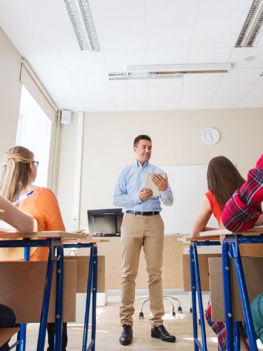 Lehrer steht vor einer Klasse und erklärt