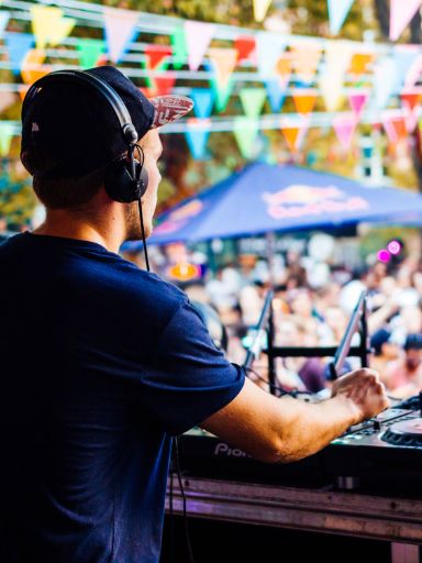 DJ am Pult vor Publikum bei Open-Air-Fest