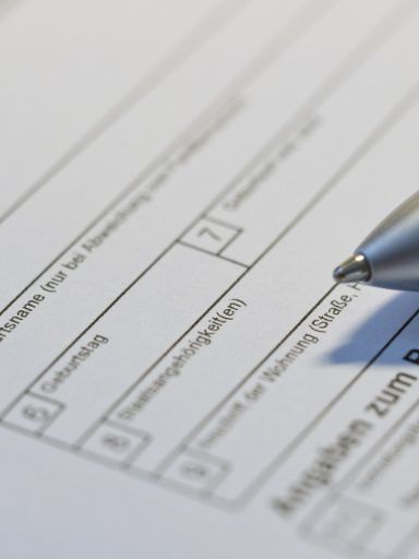 Auf einem Formular liegt ein Stift. 