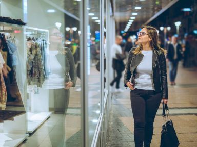 Frau vor Schaufenster eines Kleidergeschäfts
